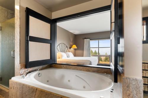 a bath tub in a room with a bed at Sun Mountain Lodge in Winthrop