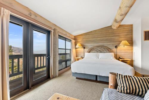 a bedroom with a bed and large windows at Sun Mountain Lodge in Winthrop