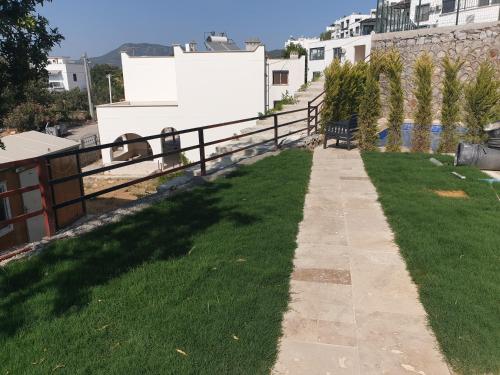 a walkway in a yard with green grass at incebel No 444 in Dalaman