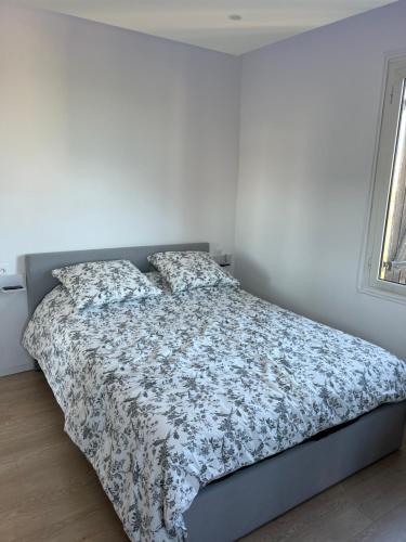 een slaapkamer met een bed met een bloemdekbed bij Appartement Nice ouest au calme 10 minutes de la plage in Nice