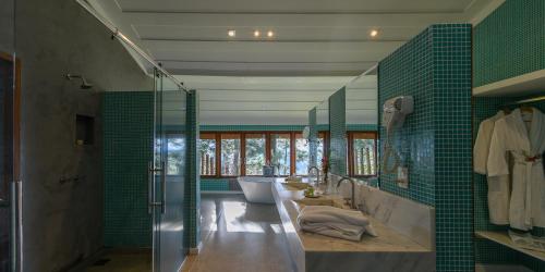a bathroom with two sinks and a tub and a shower at Quinta dos Pinhais Pouso e Charme in Santo Antônio do Pinhal