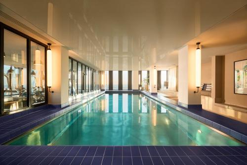 ein großer Pool in einem Gebäude in der Unterkunft Adina Apartment Hotel Munich in München