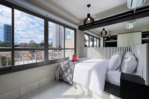 a bedroom with a bed with a view of a city at Zainalofts7Vila Mariana ao lado metrô, CASV 11 ID in Sao Paulo