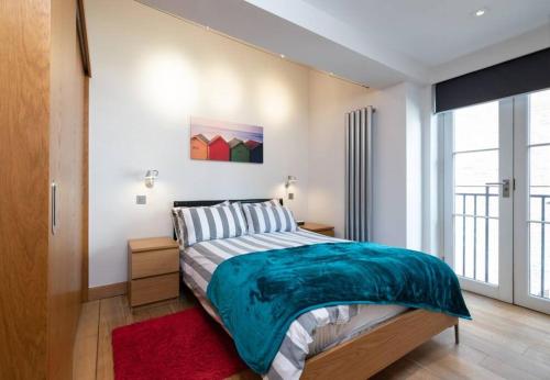 a bedroom with a large bed and a red rug at Central Two Bedroom Apartments with Free Parking in St. Albans