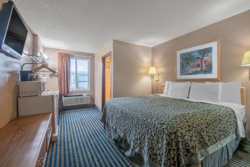 a hotel room with a bed and a television at Days Inn by Wyndham Jamestown in Jamestown