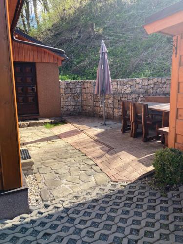 a patio with an umbrella and a table and chairs at Chalupa Nella in Velké Karlovice