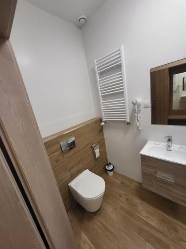 a bathroom with a toilet and a sink at Restauracja & Pokoje Gościnne Polowczyk in Miąskowo