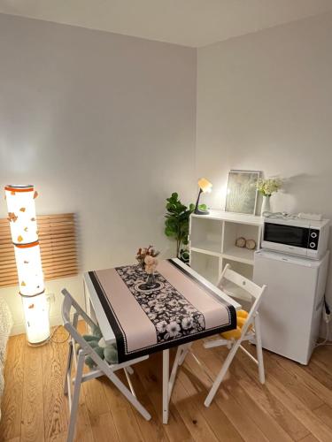 une cuisine avec une table et des chaises dans une pièce dans l'établissement Dream Dwell Paris- The 6th district Paris Historical apartment near Montparnasse, à Paris