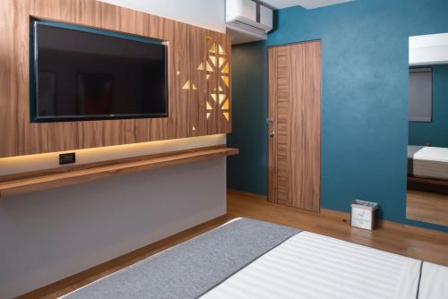 a living room with a tv and a bedroom at Hotel Flamencos Centro Histórico in Mexico City