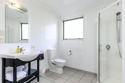 a white bathroom with a sink and a toilet at Jasmine Court Motel in Picton