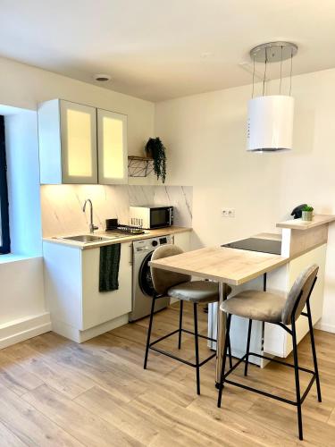 une cuisine avec une table et des chaises dans une cuisine dans l'établissement « Petit Paris » - T2 centre ville Parking/balcon, à Albertville