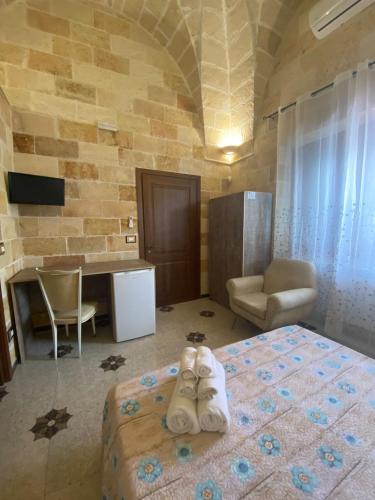 a bedroom with a bed and a desk and a chair at Il Vittoriano in Porto Cesareo
