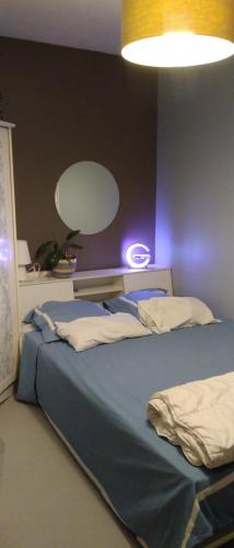 a bedroom with a bed with a light on the wall at IL & DG Immobilier in Saint-Denis