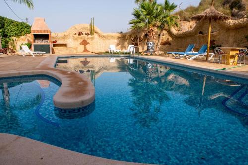 a swimming pool with blue water in a resort at Complejo rural los llanos in Mazarrón