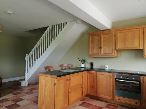 a kitchen with wooden cabinets and a staircase at Radharc Na Greine in Cork
