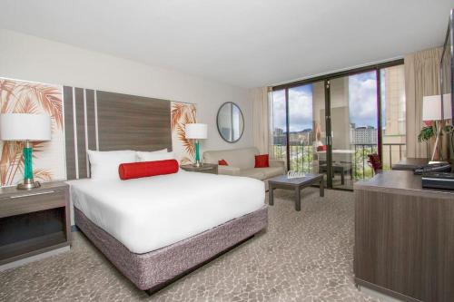 a bedroom with a large bed and a living room at Waikiki Boutique studio GREAT location PW514 in Honolulu