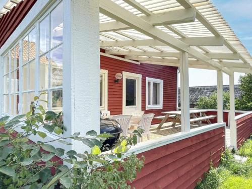 a pergola on a red house with a patio at 8 person holiday home in VALDEMARSVIK in Valdemarsvik