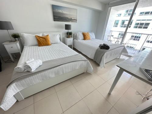 um quarto com 2 camas, uma mesa e uma janela em The Stay At Brickell Club em Miami