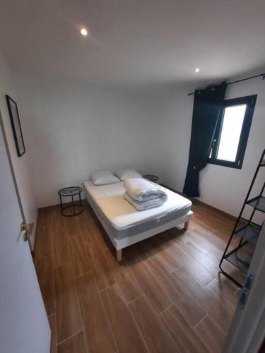 1 dormitorio con 1 cama y suelo de madera en Appartement à la campagne 
