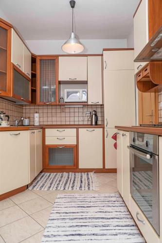 a kitchen with white cabinets and a rug at Castle View Apartment with free parking in Bratislava
