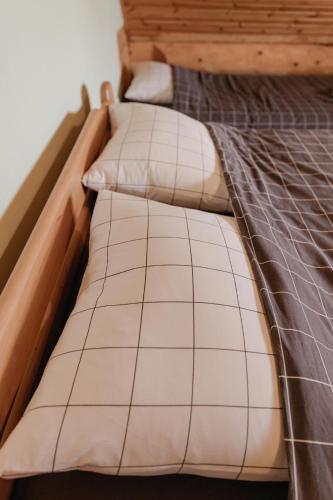 a close up of a bed with a wooden frame at Viesu nams “Kalna Raskumi” in Vecpiebalga