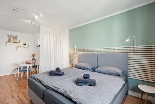 1 dormitorio con 1 cama grande y toallas. en Amalfi Apartments A01 - gemütliche 2 Zi-Wohnung mit Boxspringbetten und smart TV, en Kaiserslautern
