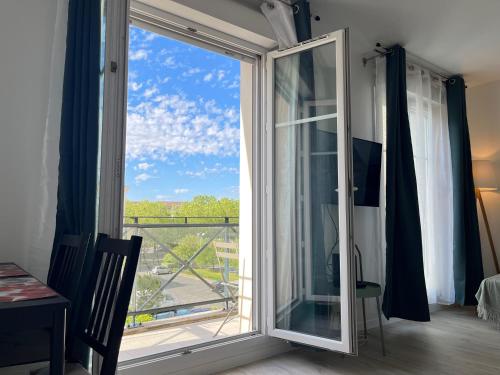 a sliding glass door with a view of a balcony at Studio Bienvenue - Louez L'Esprit Libre ! in Bussy-Saint-Georges