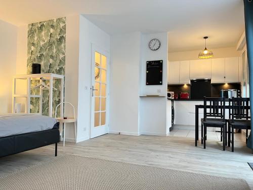une chambre avec un lit et une cuisine avec une table dans l'établissement Studio Bienvenue - Louez L'Esprit Libre !, à Bussy-Saint-Georges