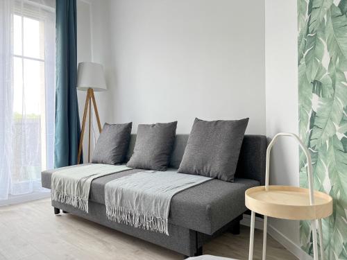 ein Wohnzimmer mit Sofa und Tisch in der Unterkunft Studio Bienvenue - Louez L'Esprit Libre ! in Bussy-Saint-Georges