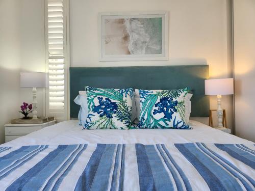 Un dormitorio con una cama azul y blanca con almohadas en KimOcean La Ballito Apartment, en Ballito