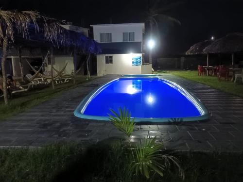 a blue swimming pool in a yard at night at Hotel La Intimidad in Antón Lizardo