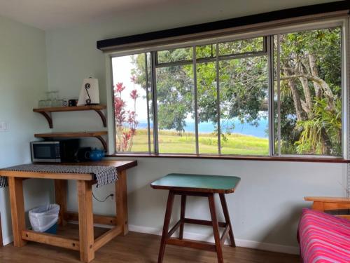 a room with a window with a table and two stools at Waipio Studio Apartment in Kukuihaele