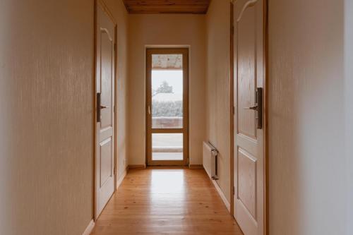 an empty hallway with a door and a window at Viesu nams “Kalna Raskumi” in Vecpiebalga