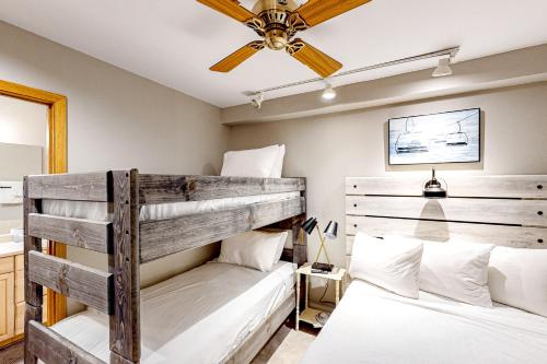 2 literas en un dormitorio con ventilador de techo en Trappeurs Lodge 1107, en Steamboat Springs