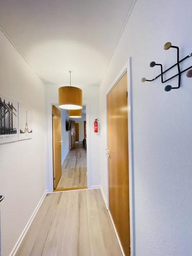 a hallway with a wooden floor and a door at aday - Great 1 bedroom central apartment in Hjørring