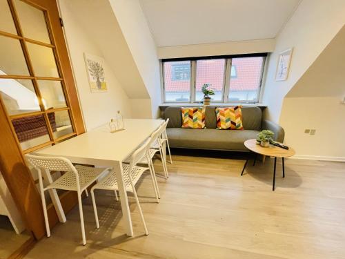 a living room with a couch and a table and chairs at aday - Great 1 bedroom central apartment in Hjørring
