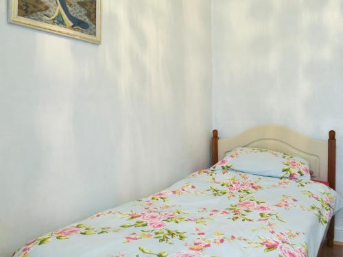 een slaapkamer met een bed met een bloemenbed bij Seagulls in Holyhead