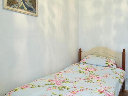 a bedroom with a bed with a floral bedspread at Seagulls in Holyhead