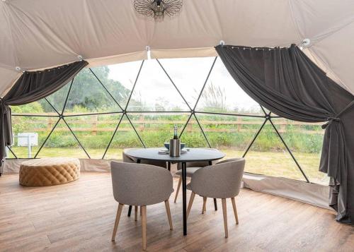 a tent with a table and chairs in front of a window at Angrove Country Park in Stokesley