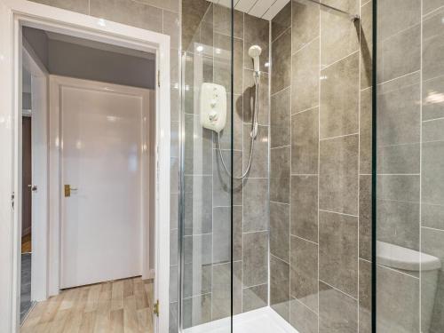 a shower with a glass door in a bathroom at Rowan Muir in Springside