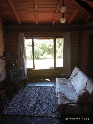 a living room with a couch and a large window at Pousada Longe Vista in Tibagi