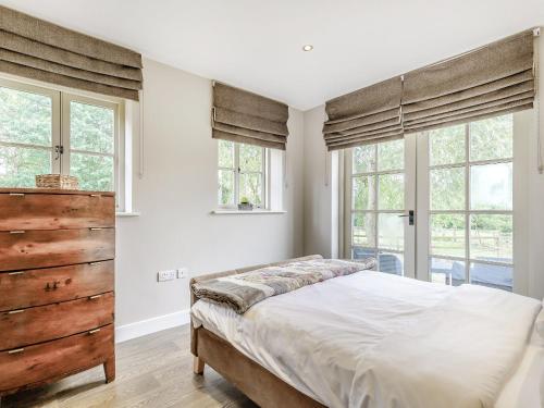 a bedroom with a large bed and windows at Little Barn in Shirland