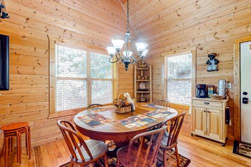 a dining room with a table and chairs and wooden walls at Tranquil Paradise in Ellijay