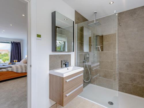 a bathroom with a shower and a sink and a mirror at Rosedene in Freshwater