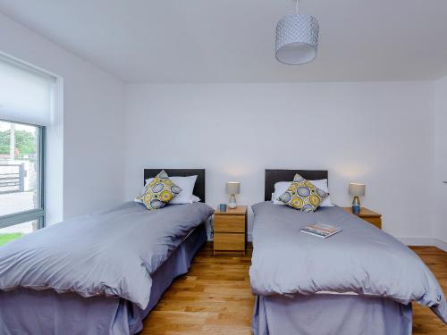 two beds sitting next to each other in a bedroom at Rosedene in Freshwater