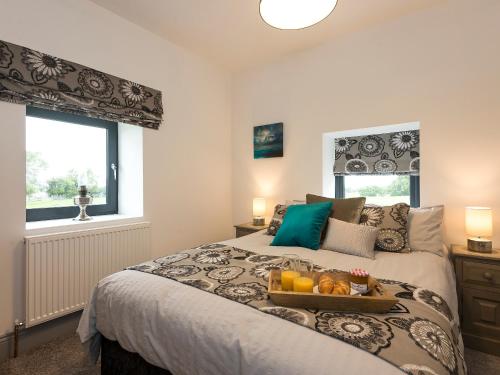 a bedroom with a bed with a tray of fruit on it at Moorgate Cottage in Kelbrook