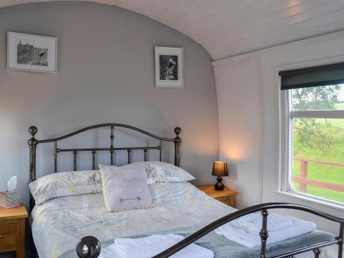 a bedroom with a bed and a window at The Carriage in Bridge of Dee