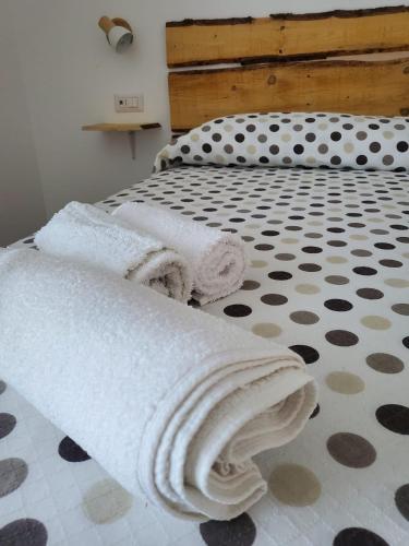 a bed with white towels on it with a polka dot floor at CaSAle in Castelfidardo