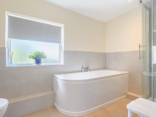 a white bathroom with a toilet and a sink at Rathlin Cottage in Cambridge