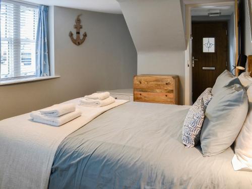 a bedroom with a bed with towels on it at The Old Toll House in Portpatrick